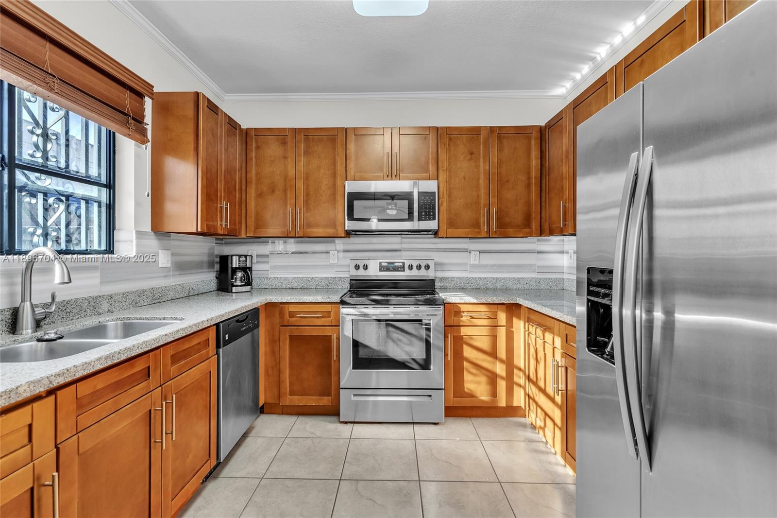 27109 Southwest 133rd Court Homestead, FL 33032 - Photo 22 of 48 a kitchen with stainless steel appliances granite countertop a stove top oven a refrigerator and a sink