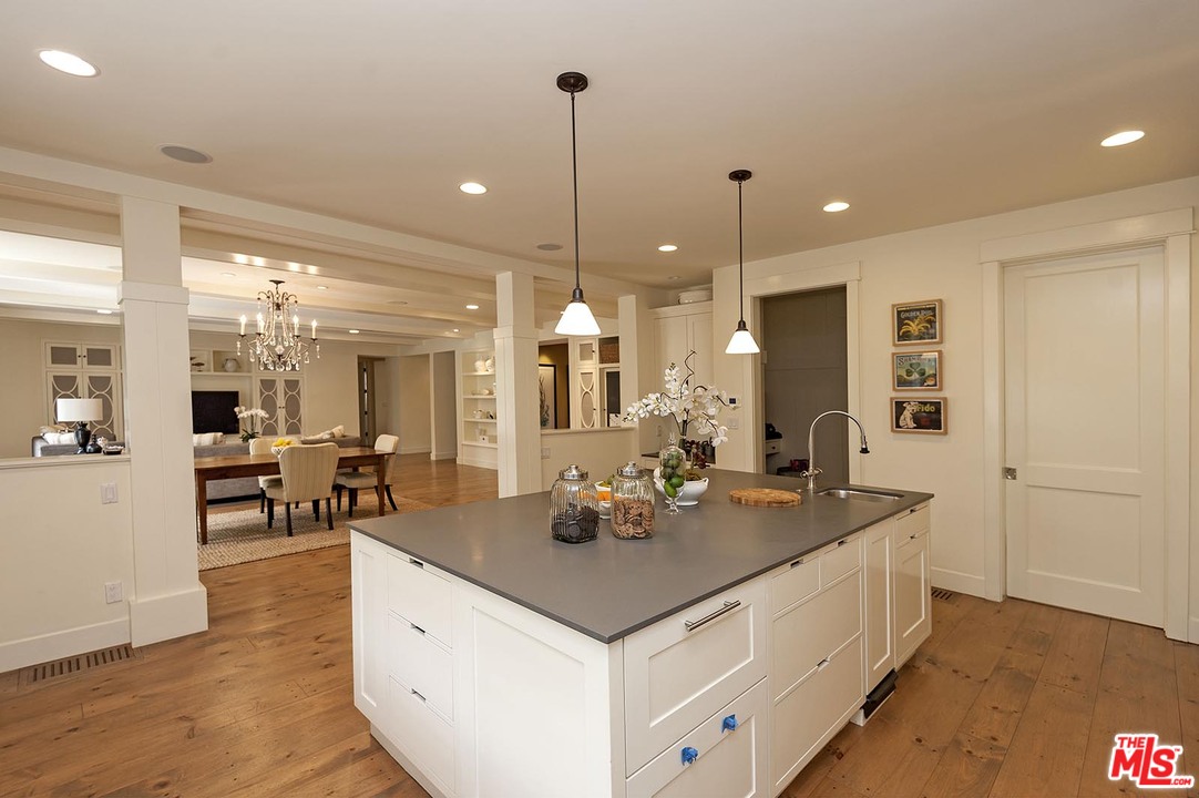 753 Ocampo Drive Pacific Palisades, CA 90272 - Photo 25 of 53 a dining hall with stainless steel appliances granite countertop a sink a dining table and chairs with wooden floor