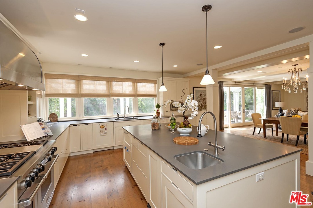 753 Ocampo Drive Pacific Palisades, CA 90272 - Photo 26 of 53 a kitchen with counter top space a sink appliances and wooden floor