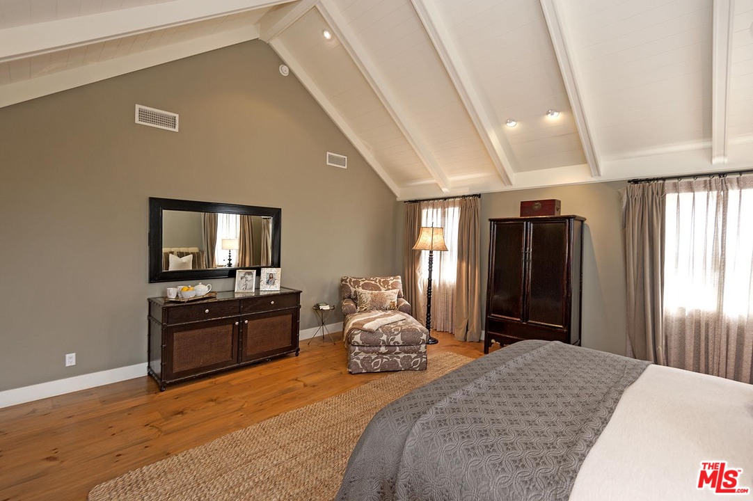 753 Ocampo Drive Pacific Palisades, CA 90272 - Photo 39 of 53 a bedroom with a bed and dresser with mirror