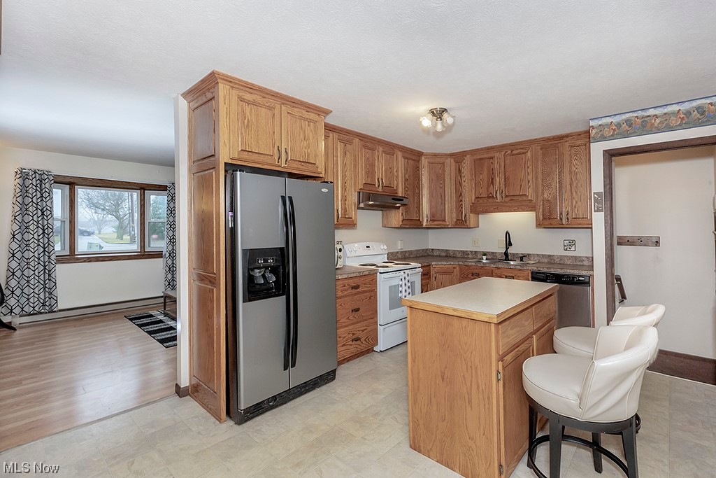39102 Chestnut Ridge Road Elyria, OH 44035 - Photo 14 of 44 Kitchen with a center island, sink, a kitchen bar, appliances with stainless steel finishes, and light wood-type flooring
