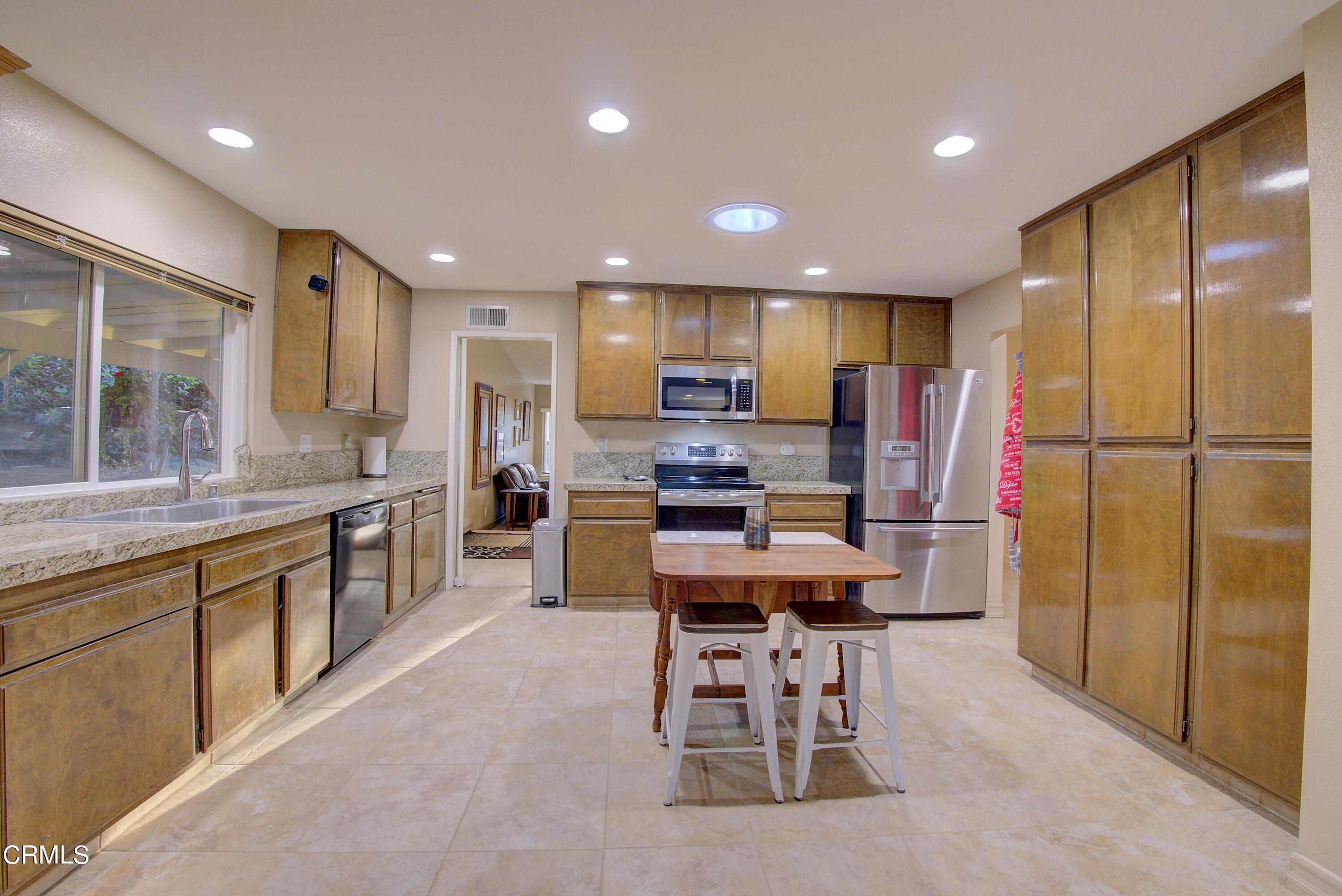 2606 Wheatfield Circle Simi Valley, CA 93063 - Photo 50 of 60 a kitchen with stainless steel appliances kitchen island granite countertop a sink refrigerator and cabinets