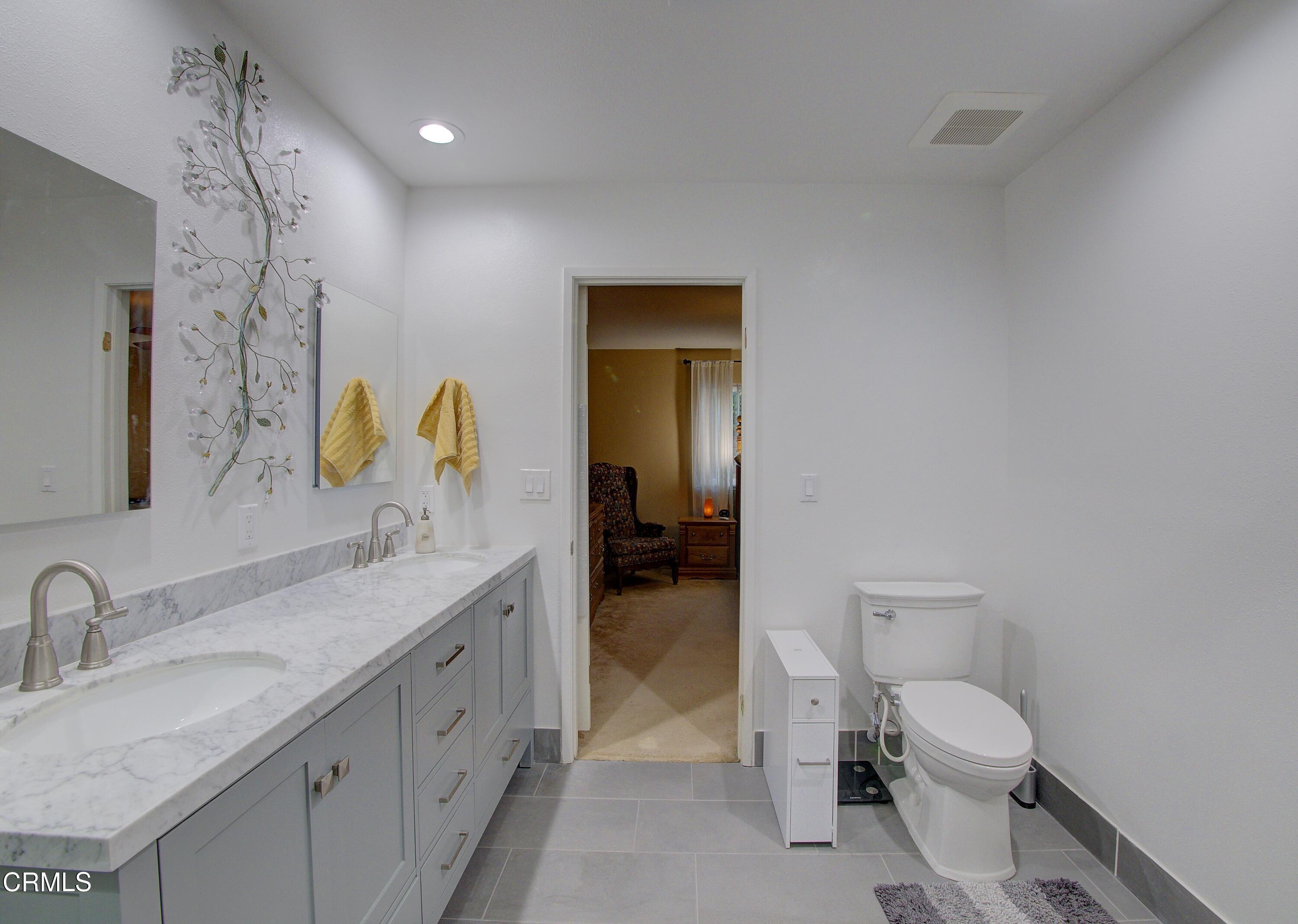 2606 Wheatfield Circle Simi Valley, CA 93063 - Photo 58 of 60 a bathroom with a granite countertop sink mirror vanity and toilet