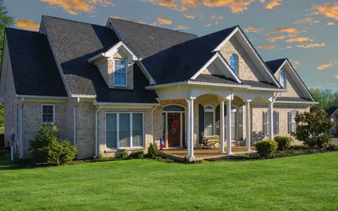 a view of a house with a swimming pool and a yard