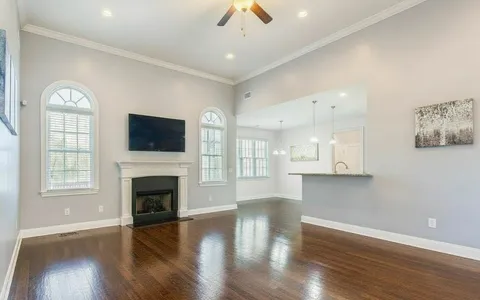 a living room with furniture and a view of kitchen
