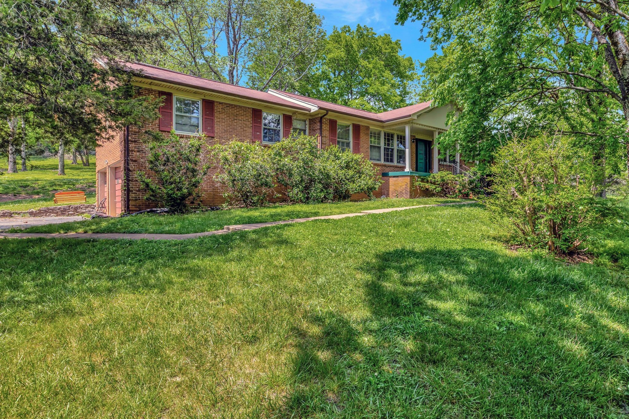 a front view of a house with a yard and trees