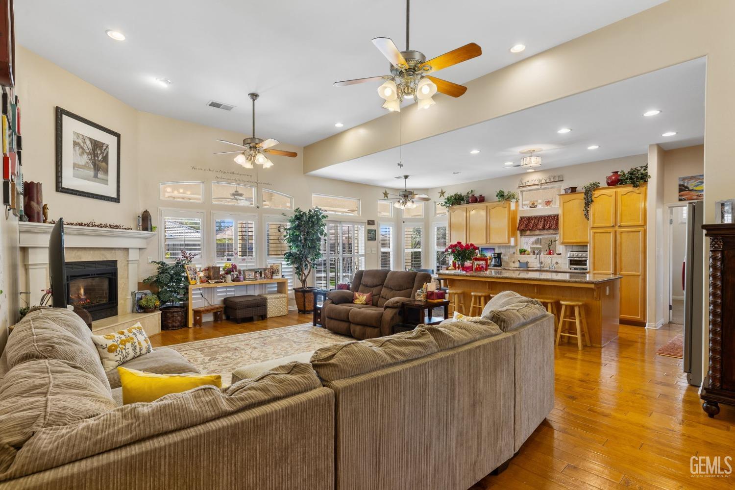 Undisclosed Address Bakersfield, CA 93313 - Photo 12 of 49 a living room with furniture a fireplace and a kitchen view