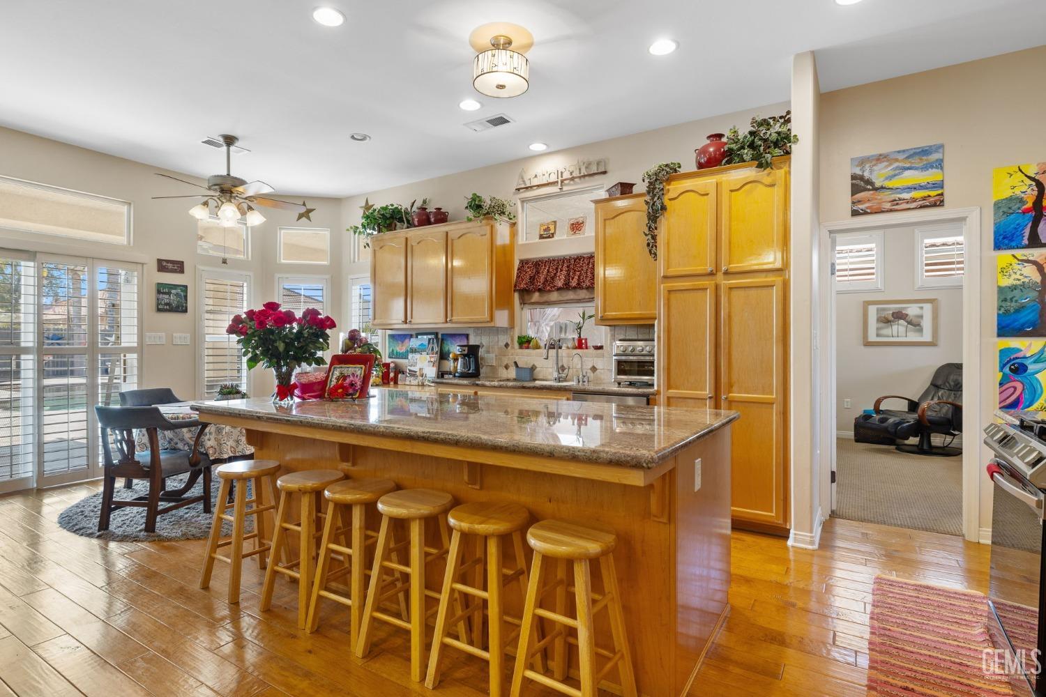 Undisclosed Address Bakersfield, CA 93313 - Photo 19 of 49 a kitchen area with stainless steel appliances kitchen island granite countertop a refrigerator and a dining table