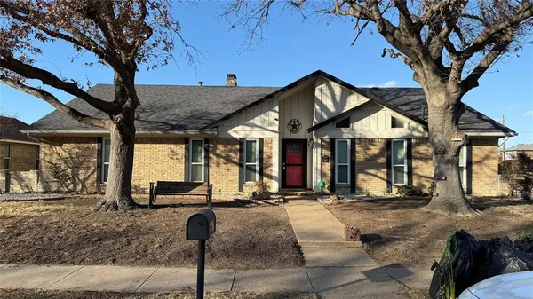 a front view of a house with a tree