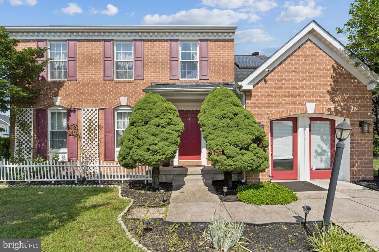 Charming brick home with lush greenery.