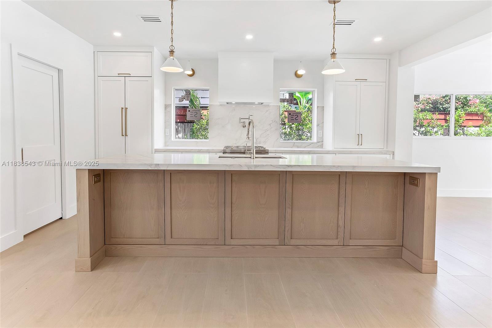 Normandy Isle Miami Beach, FL 33141 - Photo 16 of 43 a kitchen with kitchen island white cabinets and refrigerator
