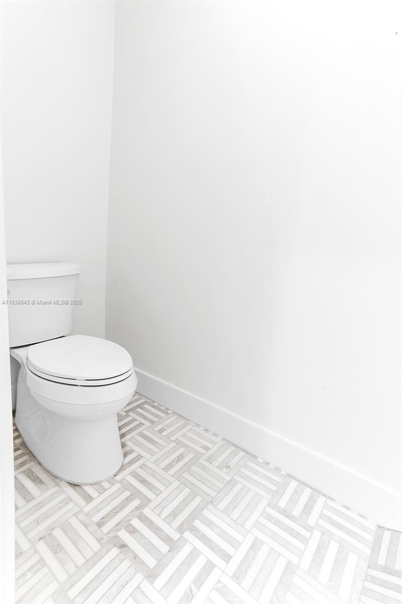 Normandy Isle Miami Beach, FL 33141 - Photo 21 of 43 a bathroom with a toilet and a rug