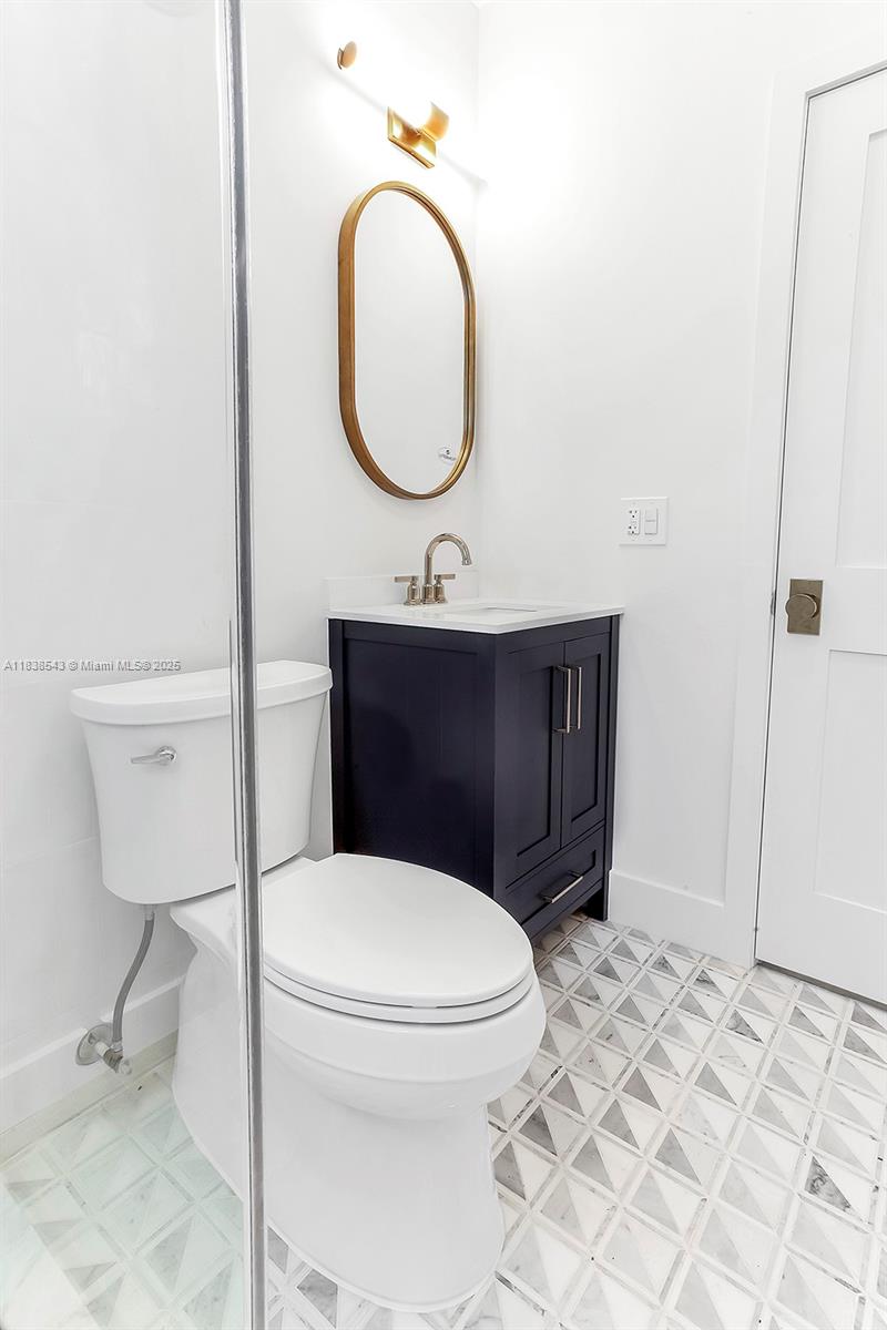 Normandy Isle Miami Beach, FL 33141 - Photo 23 of 43 a bathroom with a toilet a sink and a mirror