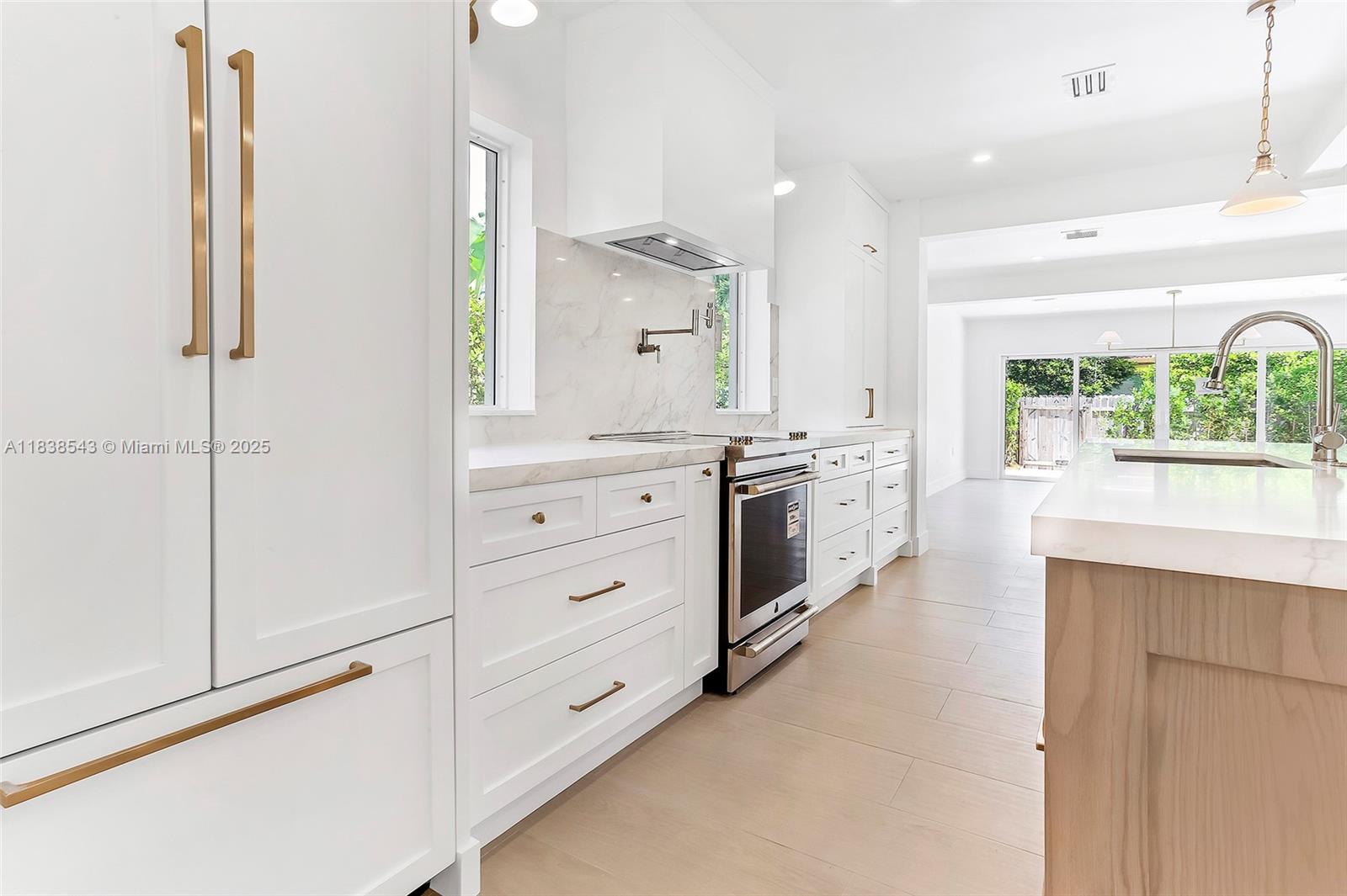 Normandy Isle Miami Beach, FL 33141 - Photo 25 of 43 a large white kitchen with stainless steel appliances a stove and a window