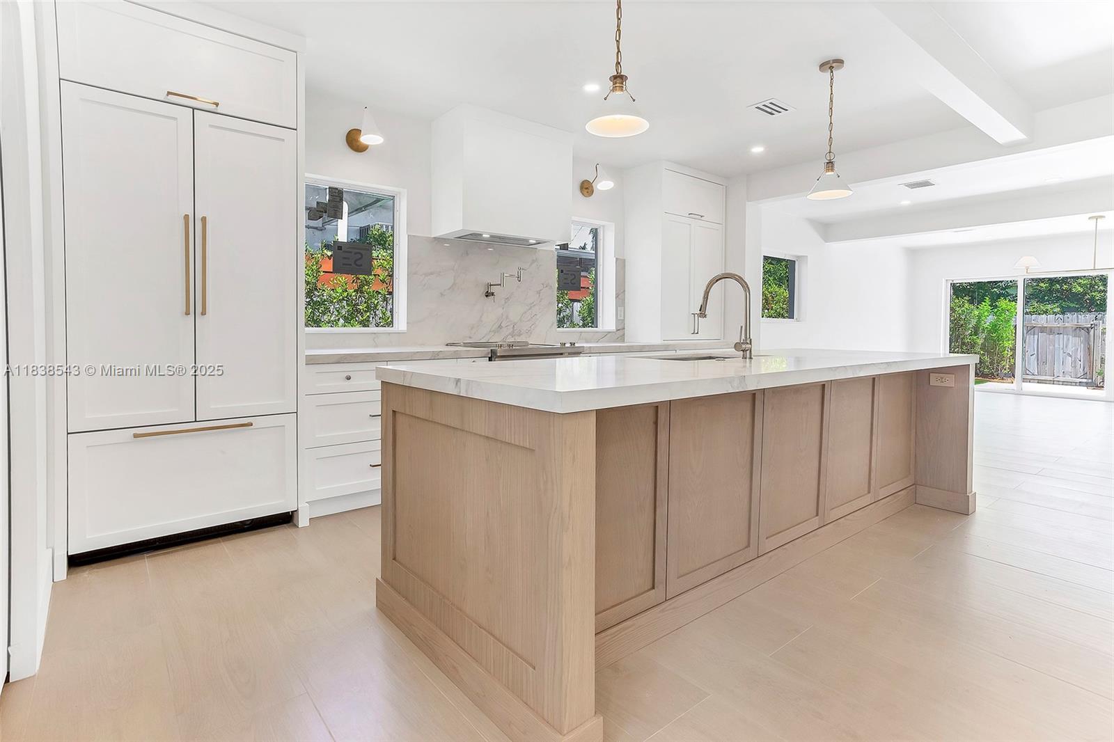 Normandy Isle Miami Beach, FL 33141 - Photo 26 of 43 a kitchen with kitchen island white cabinets and white appliances