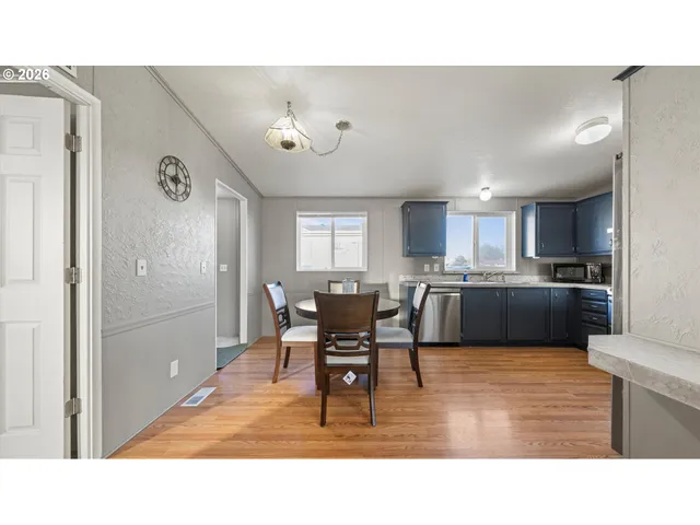 a living room with stainless steel appliances kitchen island granite countertop a refrigerator and cabinets