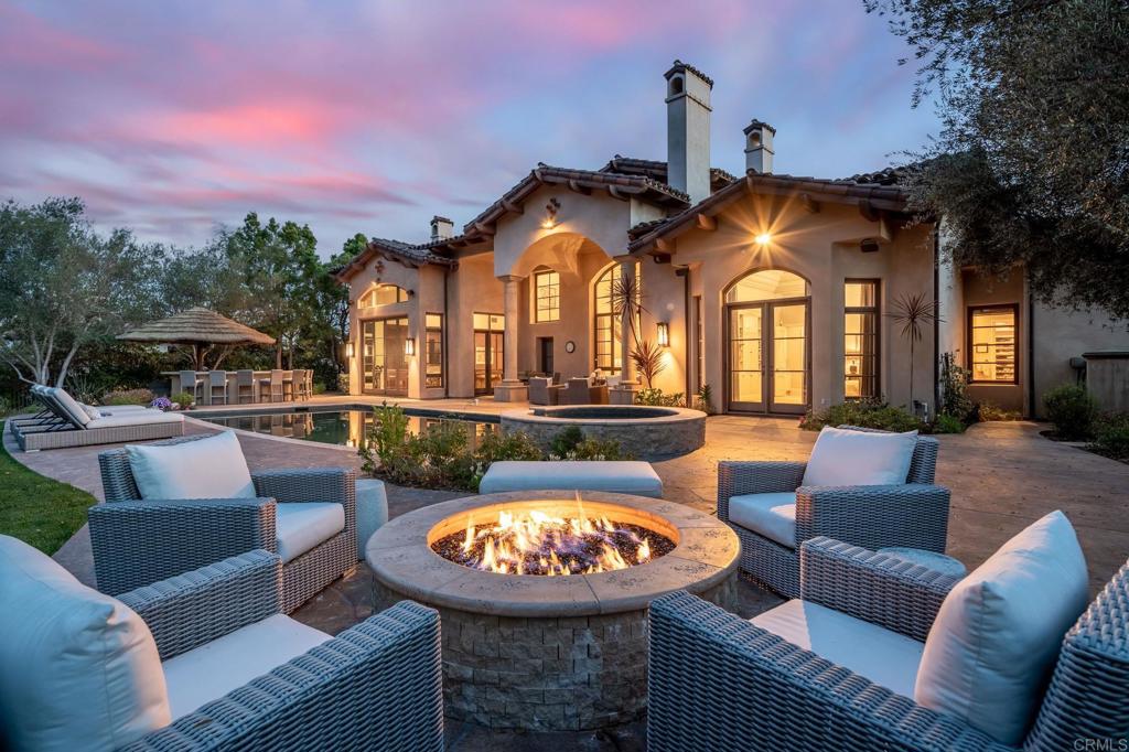 a view of a swimming pool with couches chairs and a fire pit