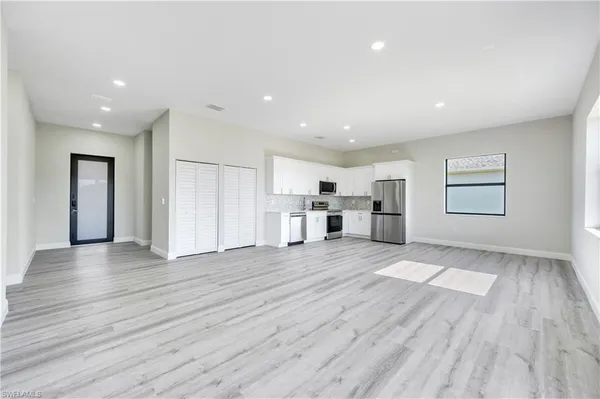 a view of a kitchen with wooden floor and windows