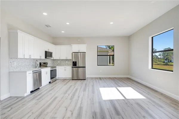 a kitchen with white cabinets and stainless steel appliances