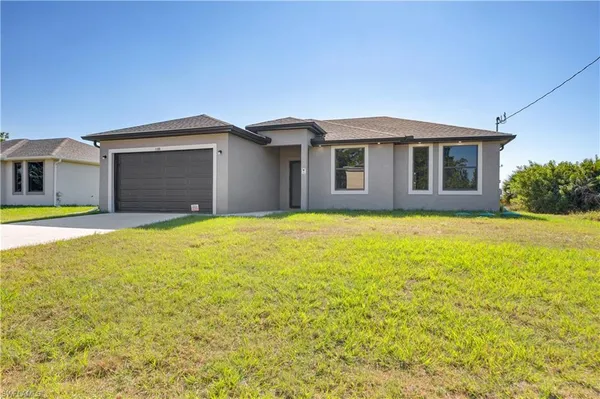 a front view of a house with yard and garage
