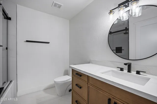 a bathroom with a sink toilet and a mirror