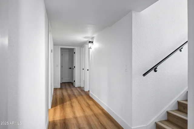a view of a hallway with wooden floor and staircase