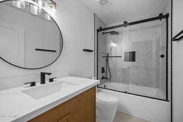 a bathroom with a sink a toilet and a mirror