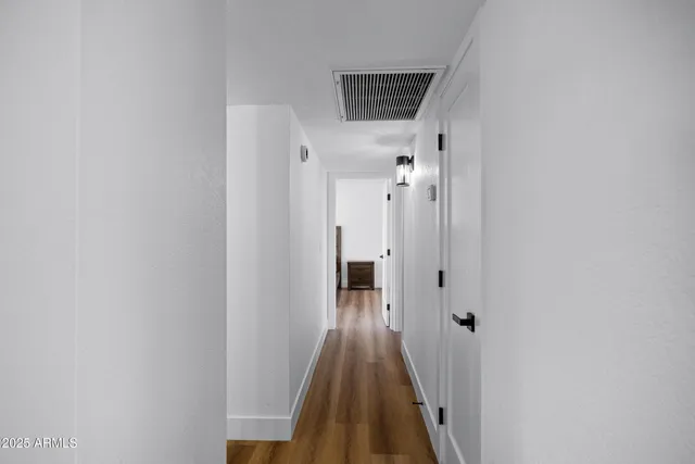 a view of a hallway with wooden floor and staircase
