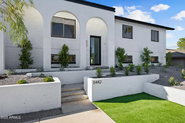 a view of a house with pool and potted plants