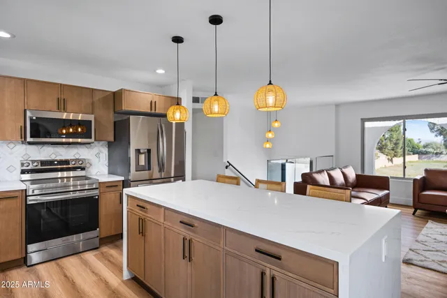 a kitchen with stainless steel appliances granite countertop a stove a sink and a refrigerator