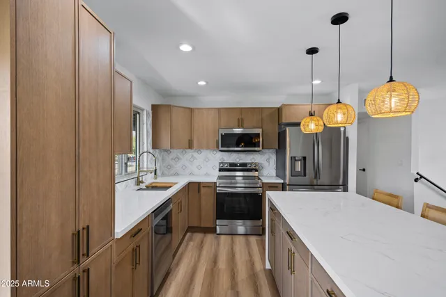 a kitchen with stainless steel appliances a stove center island a cabinets and a chandelier