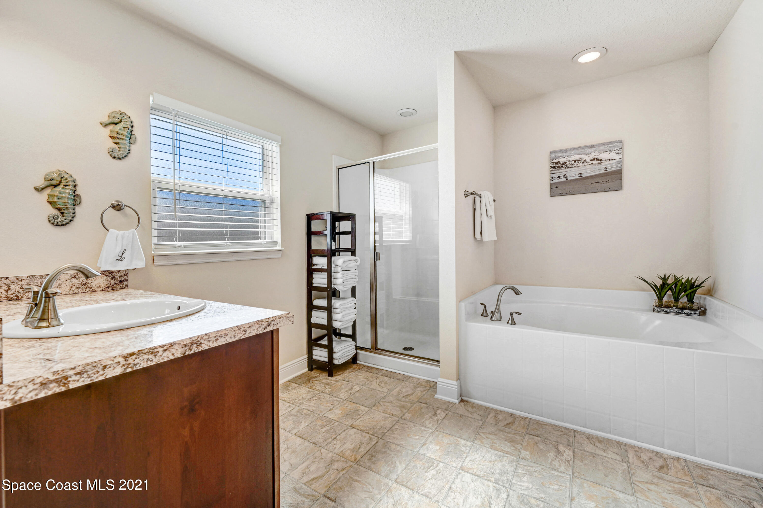 737 Atlantis Road Southeast Palm Bay, FL 32909 - Photo 14 of 29 a spacious bathroom with a tub sink and mirror