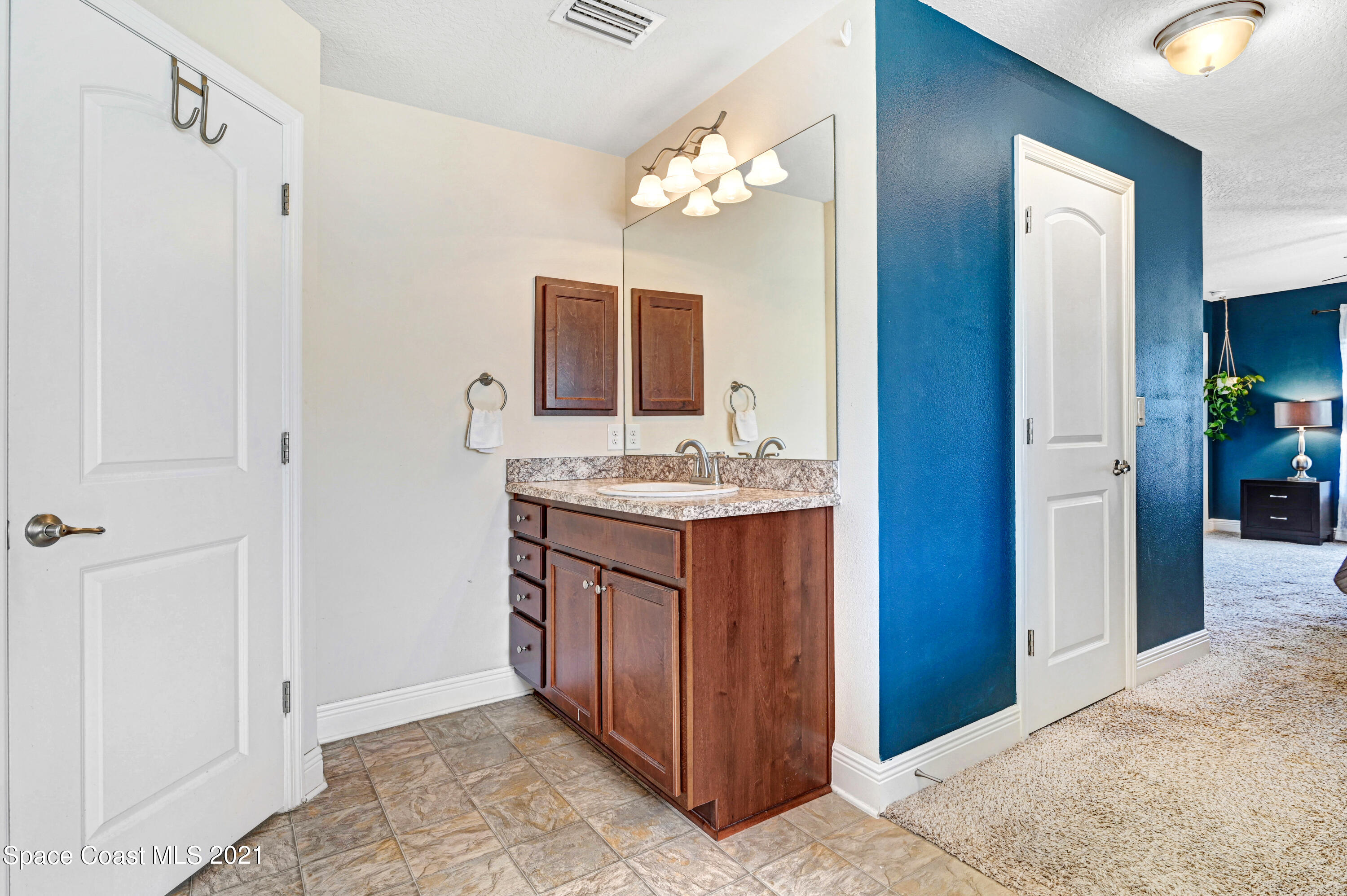 737 Atlantis Road Southeast Palm Bay, FL 32909 - Photo 15 of 29 a bathroom with a granite countertop sink a mirror and a vanity