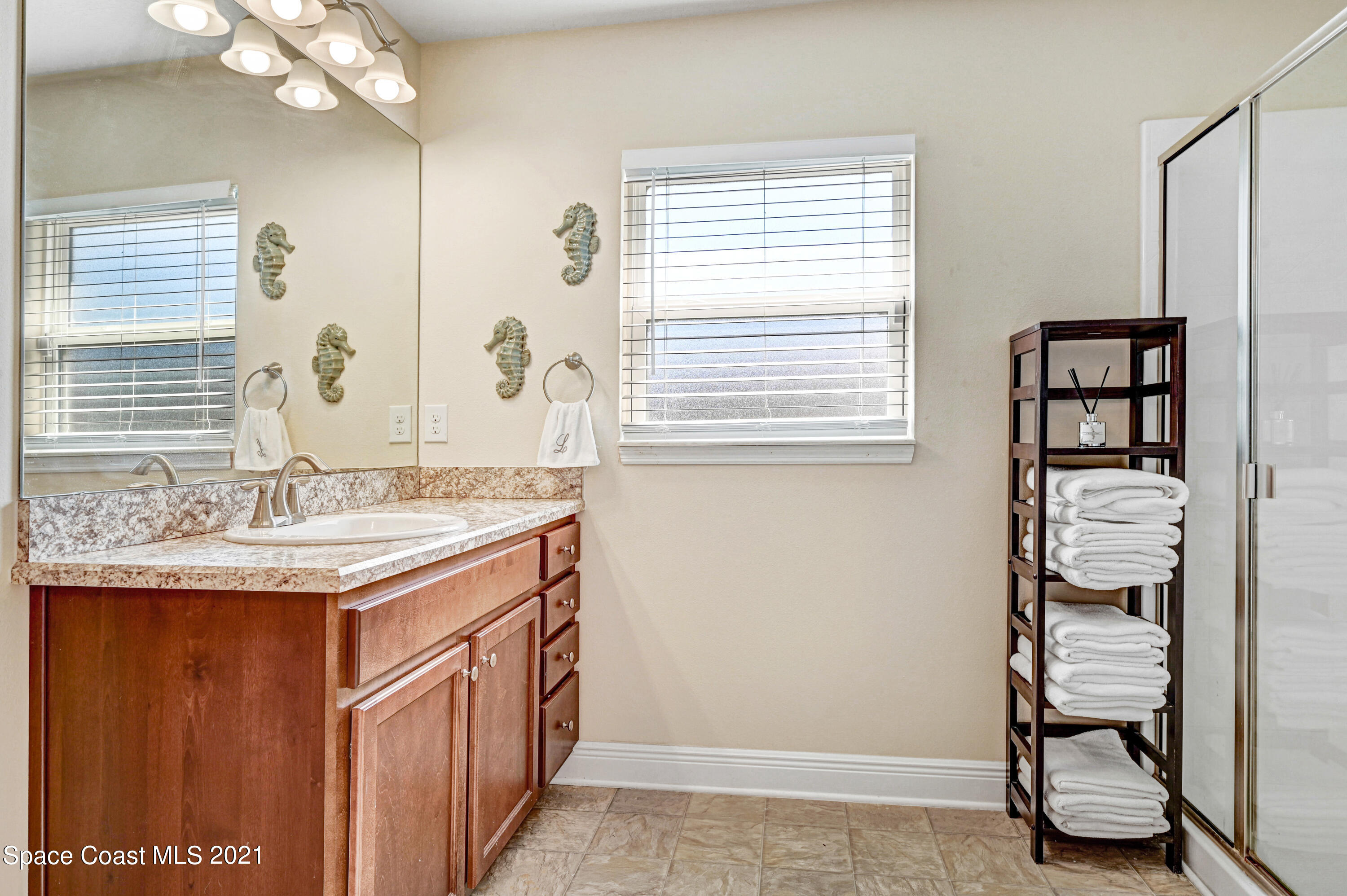 737 Atlantis Road Southeast Palm Bay, FL 32909 - Photo 16 of 29 a bathroom with a granite countertop sink a mirror and a shower