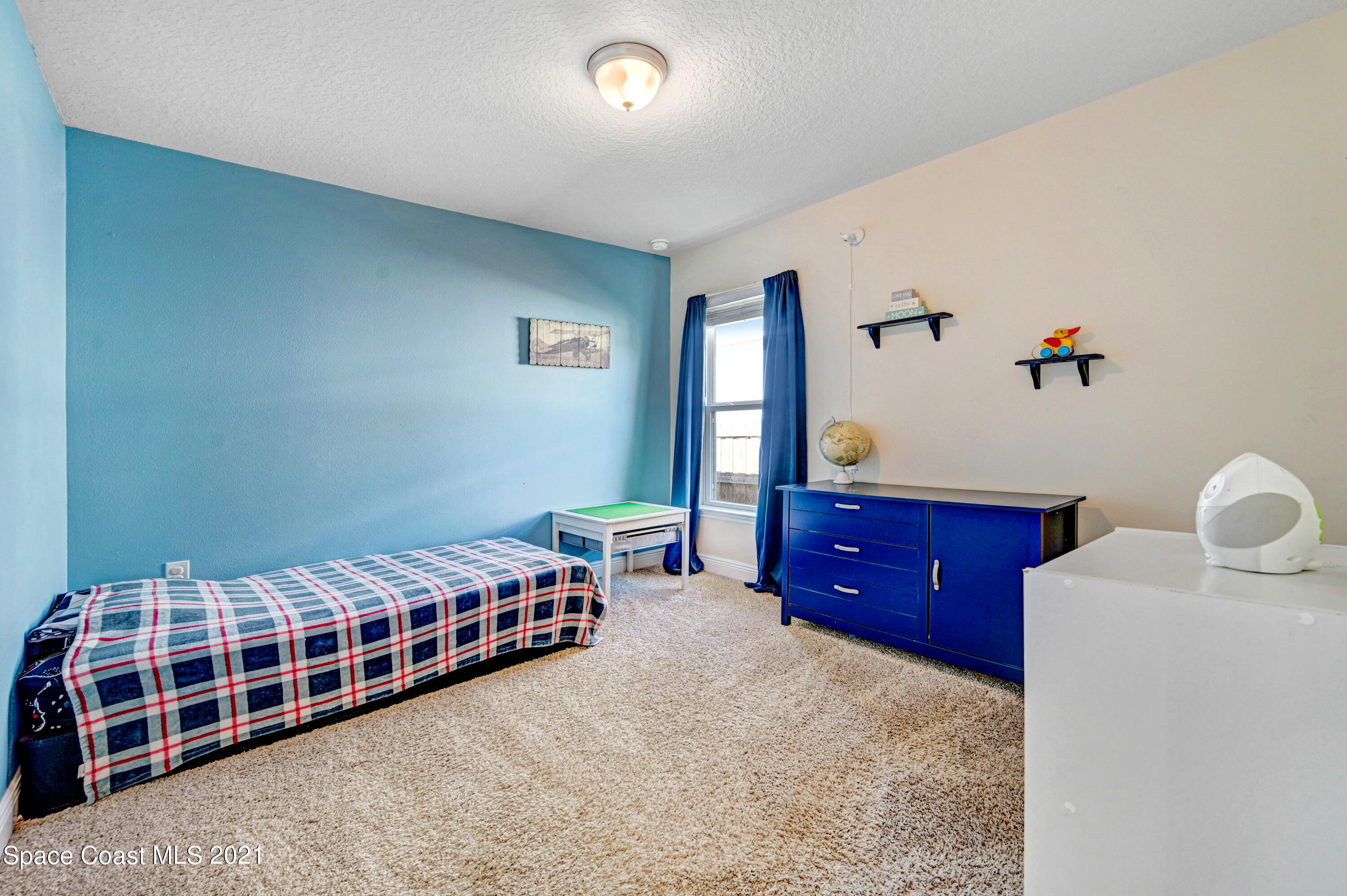 737 Atlantis Road Southeast Palm Bay, FL 32909 - Photo 20 of 29 a bedroom with furniture and a window