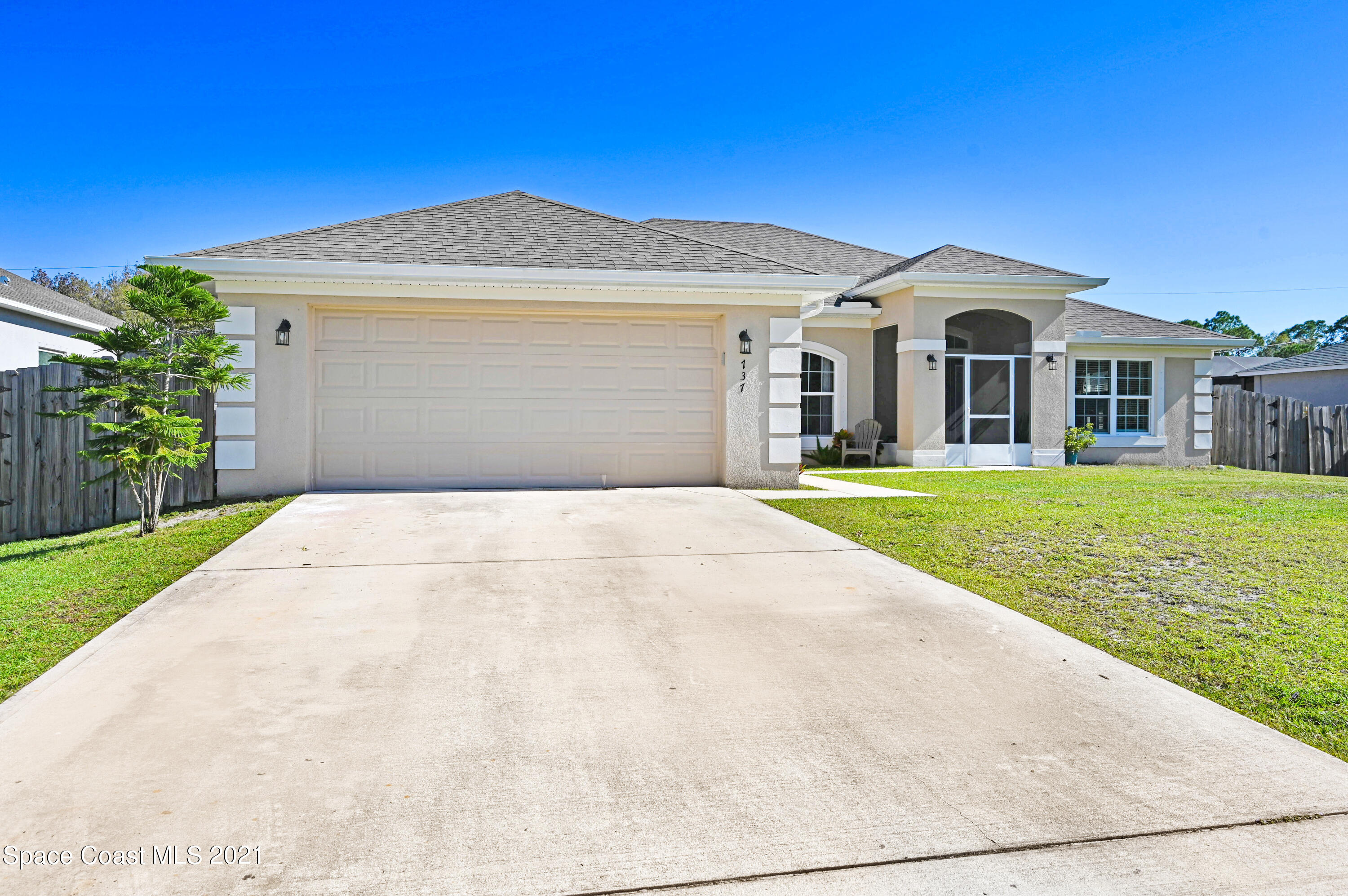737 Atlantis Road Southeast Palm Bay, FL 32909 - Photo 2 of 29 a front view of a house with a garden and yard