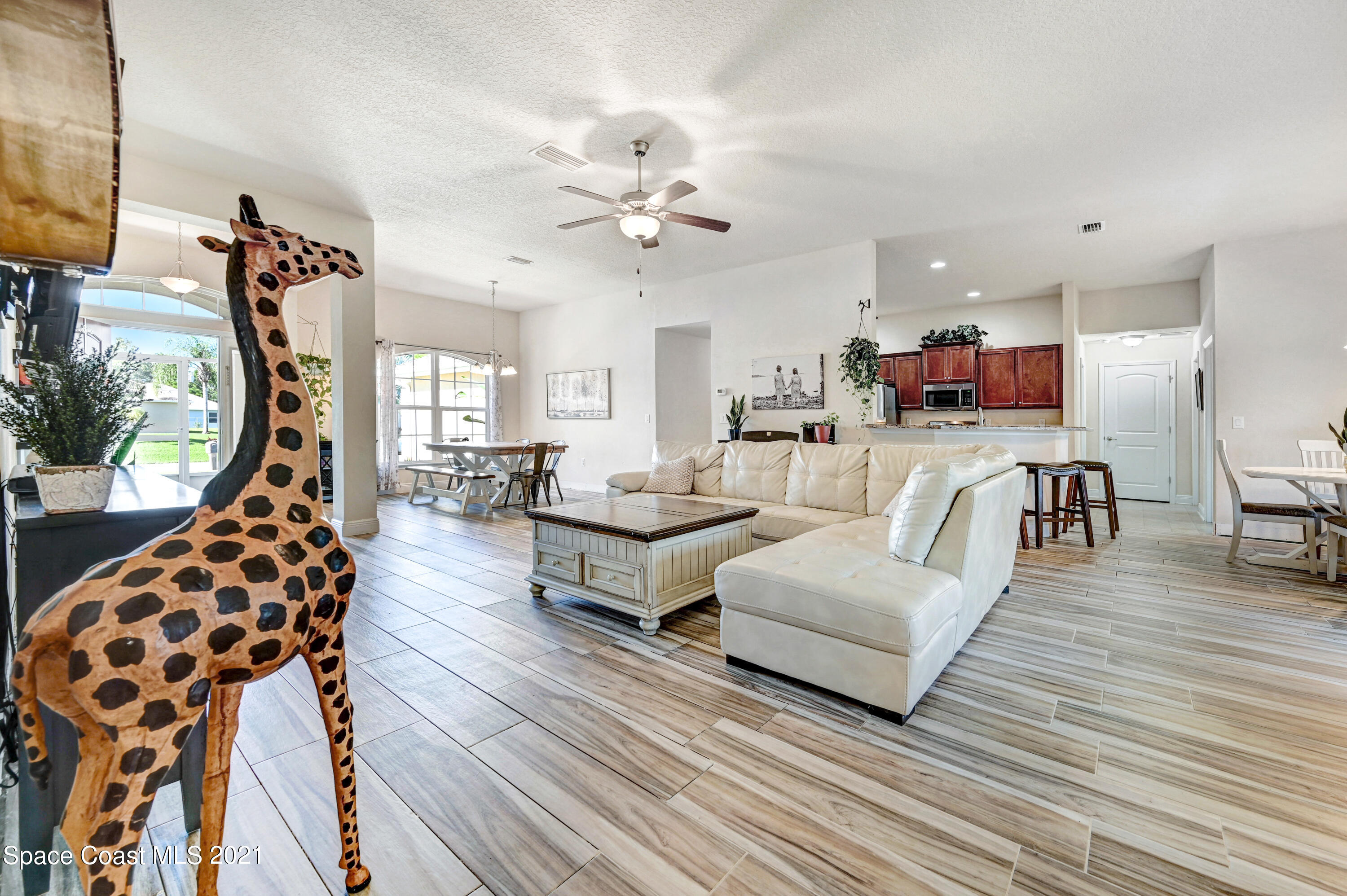 737 Atlantis Road Southeast Palm Bay, FL 32909 - Photo 5 of 29 a living room with furniture and a large mirror with wooden floor