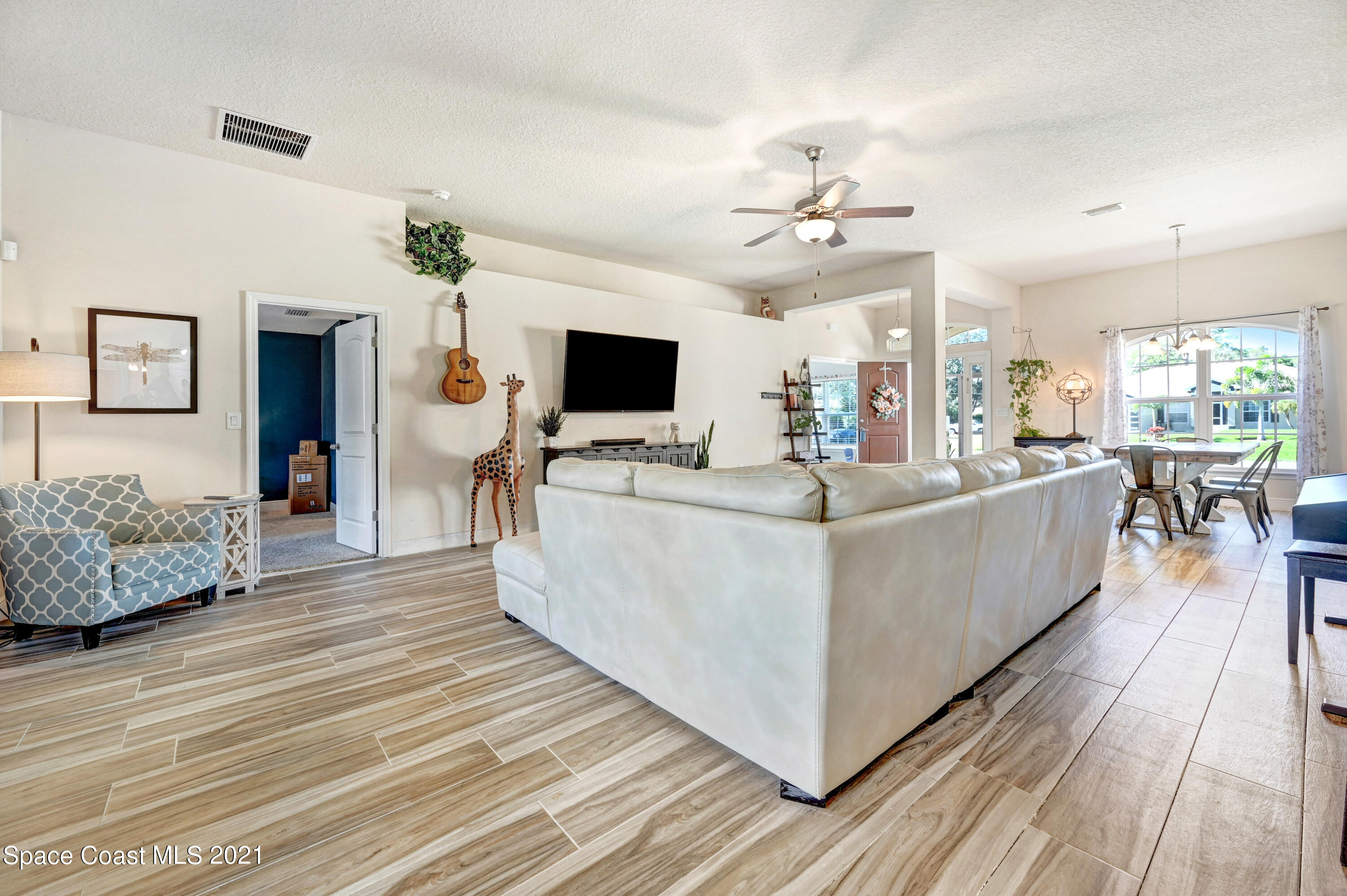 737 Atlantis Road Southeast Palm Bay, FL 32909 - Photo 6 of 29 a living room with furniture and a flat screen tv