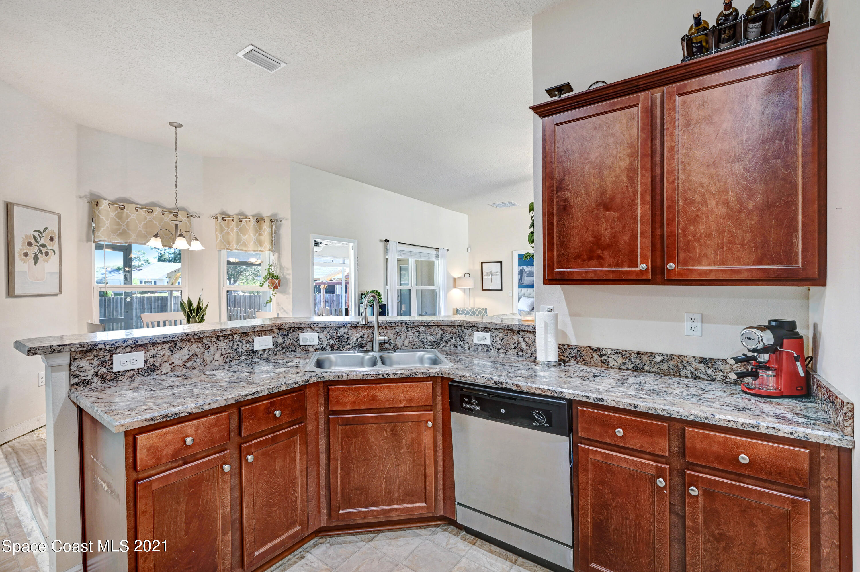 737 Atlantis Road Southeast Palm Bay, FL 32909 - Photo 7 of 29 a kitchen with granite countertop a sink and cabinets