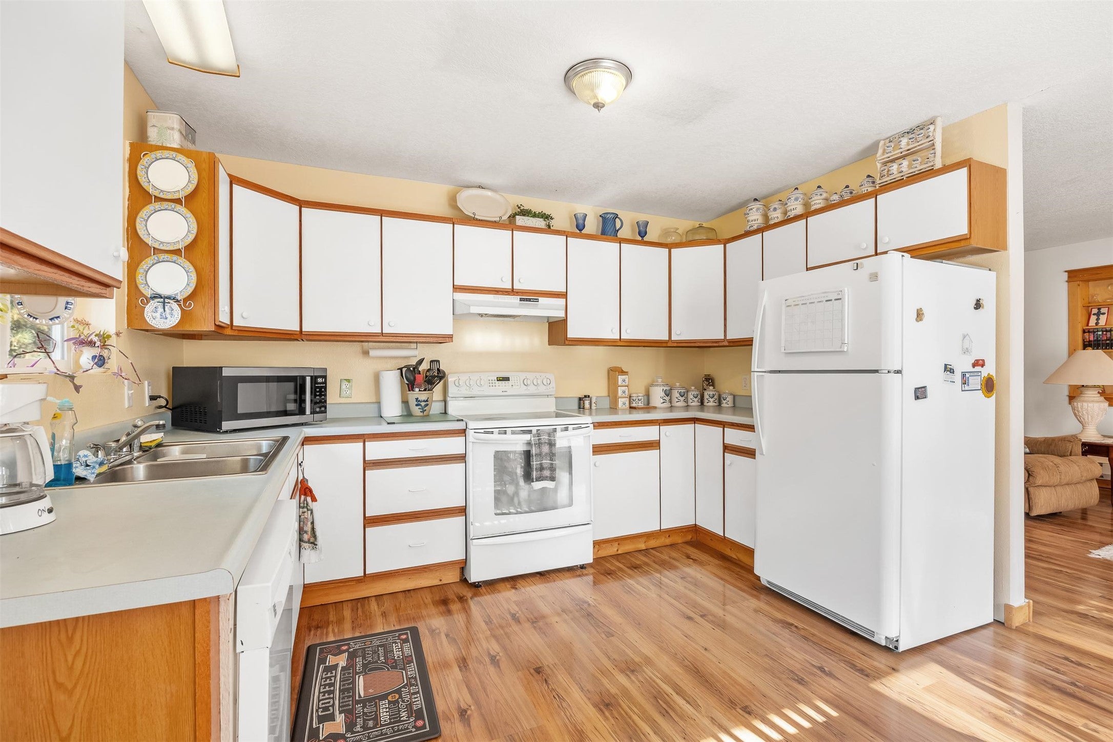 212 St Marys Road Stevensville, MT 59870 - Photo 24 of 39 Kitchen with white cabinetry, brown cabinetry, and white appliances