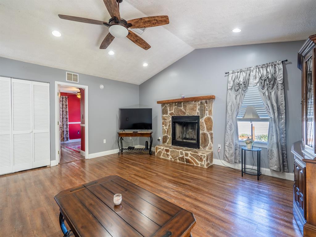 13425 Maple Drive Fort McCoy, FL 32134 - Photo 11 of 41 a living room with furniture a flat screen tv and a fireplace