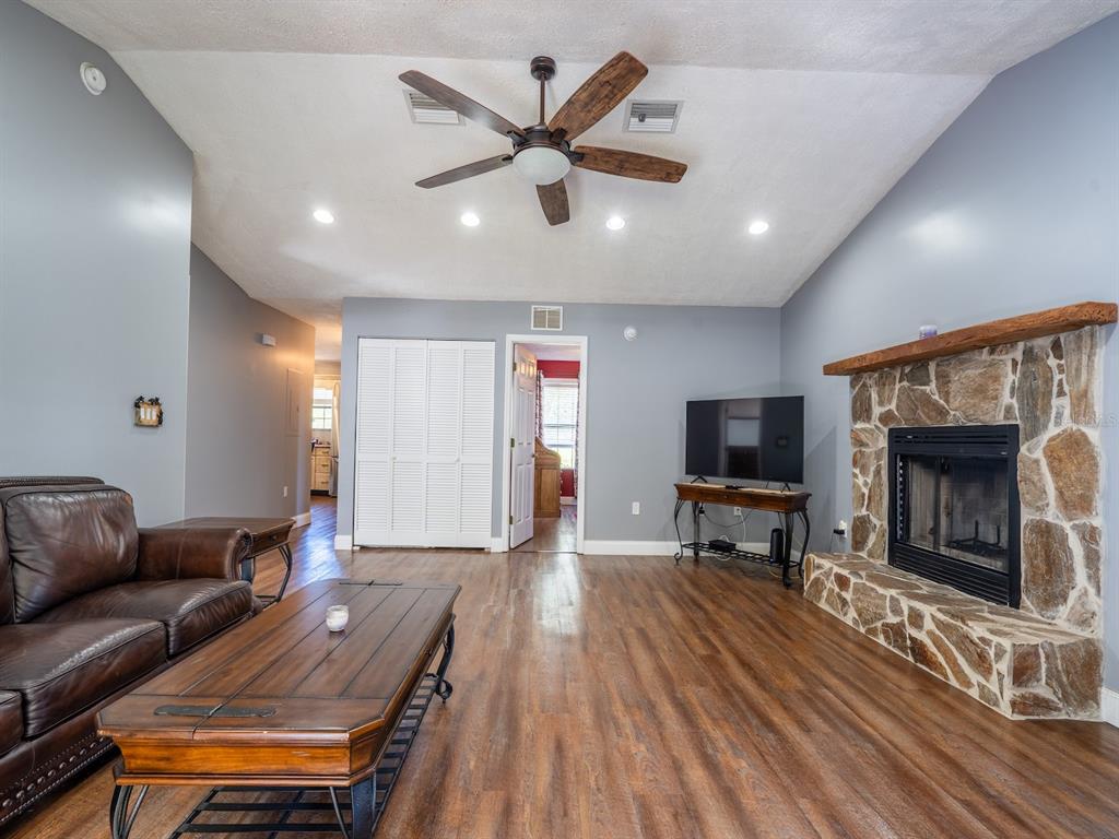 13425 Maple Drive Fort McCoy, FL 32134 - Photo 12 of 41 a living room with furniture a fireplace and a flat screen tv