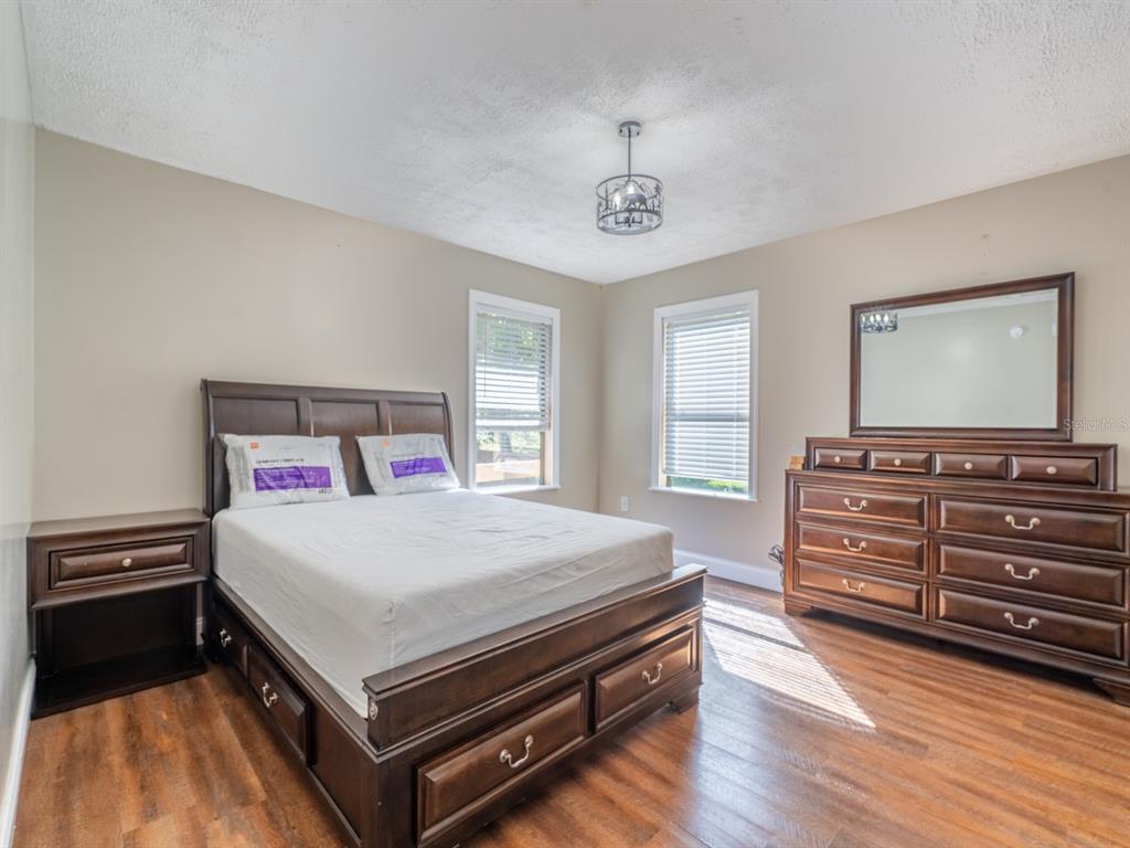 13425 Maple Drive Fort McCoy, FL 32134 - Photo 13 of 41 a bedroom with a bed and wooden floor