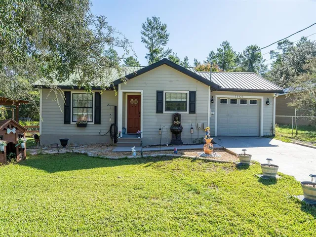 a view of a house with backyard and sitting area