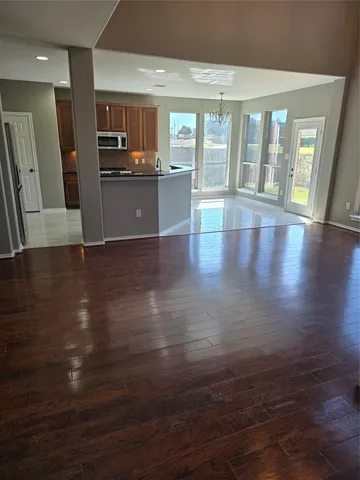 an open kitchen with a sink and dishwasher with wooden floor