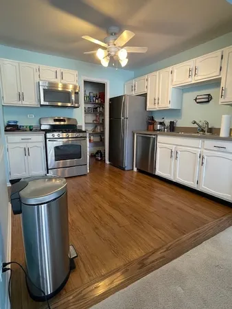 a kitchen with granite countertop a refrigerator stove top oven and sink