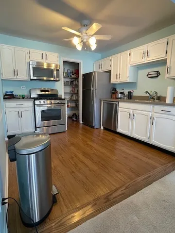 a kitchen with granite countertop a refrigerator stove top oven and sink
