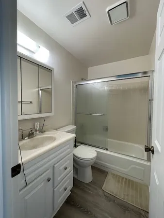 a bathroom with a double vanity sink toilet mirror and shower