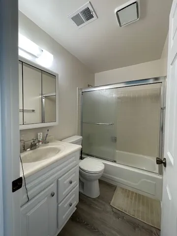 a bathroom with a double vanity sink toilet mirror and shower