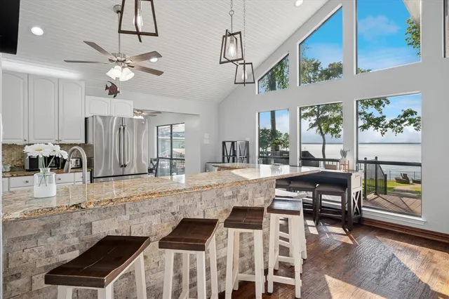 a kitchen with stainless steel appliances granite countertop wooden cabinets a dining table and chairs